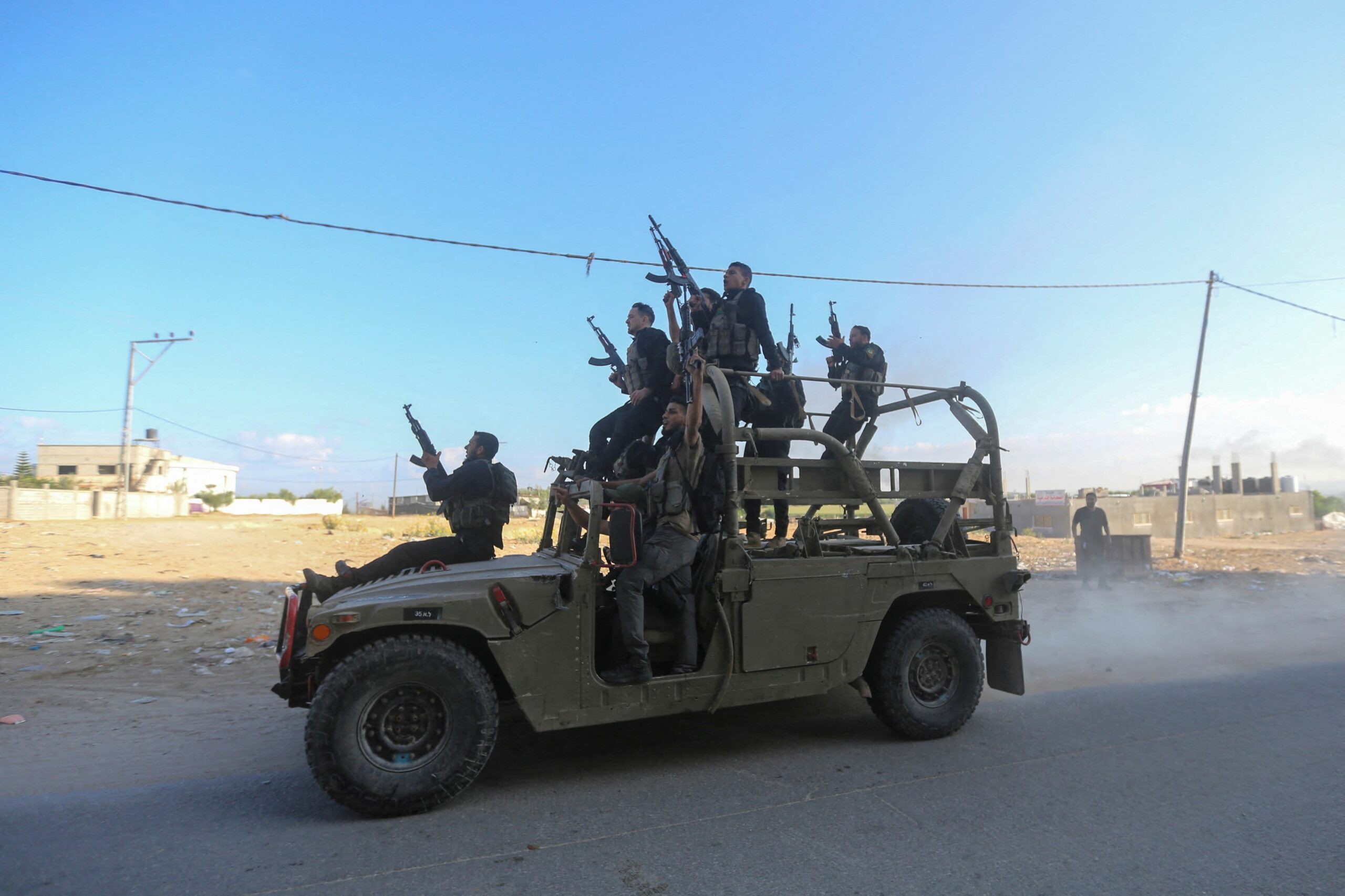Palestinian militants ride an Israeli military vehicle