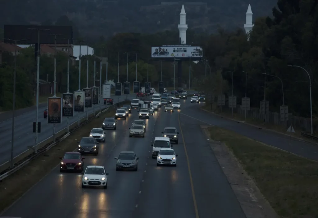 Evening traffic with numerous cars on a busy South African roadway, with billboards.