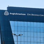 Anglo American and De Beers Group logos on a modern glass office building facade.