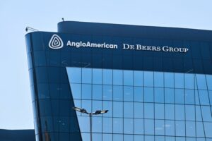 Anglo American and De Beers Group logos on a modern glass office building facade.