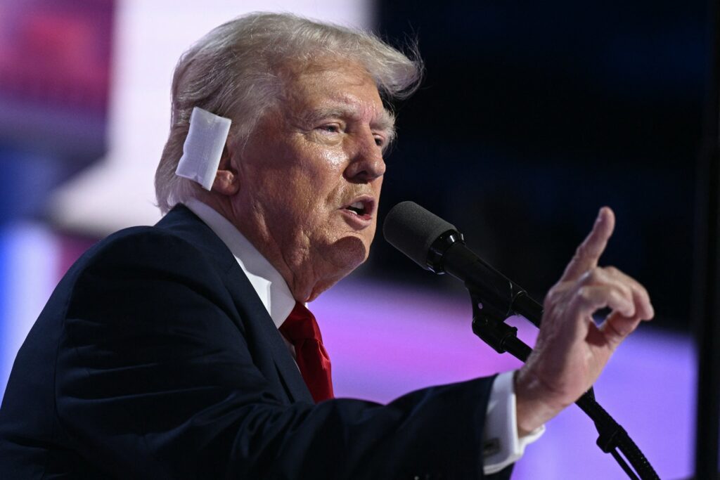 Donald Trump, bandaged, speaks at the Republican National Convention, emphasizing unity and resilience.