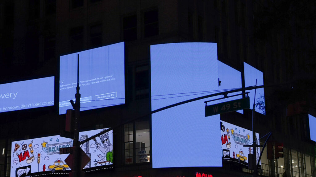 Error messages on digital billboards in Times Square during a global tech outage caused by CrowdStrike's update defect