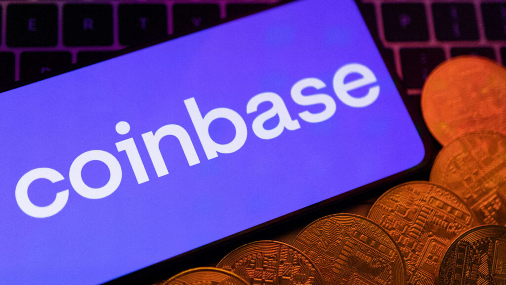 Coinbase logo on a screen with cryptocurrency coins displayed below