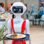 Nadia, a robot waiter at Robot Café, holding a tray with a meal, showcasing the use of robotics in the dining industry.