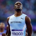 Tebogo letsile standing proudly in his botswana uniform after winning the 200 meter final at the paris 2024 olympics