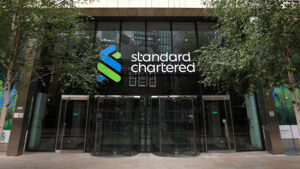 Entrance of Standard Chartered Bank headquarters with the company's logo on the building facade.