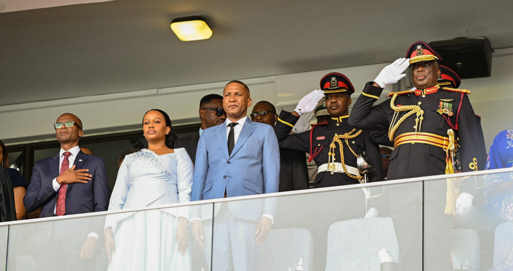 President duma boko first lady kaone boko and vice president ndaba gaolathe standing together singing the national anthem at the inauguration ceremony with military officials in salute beside them