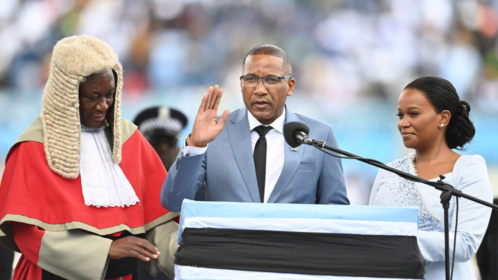 Duma boko taking the presidential oath with his right hand raised alongside his wife kaone boko and botswanas chief justice terence rannowane during the inauguration ceremony