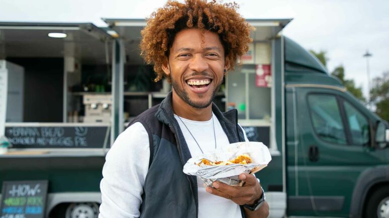 Man standing next to a food truck