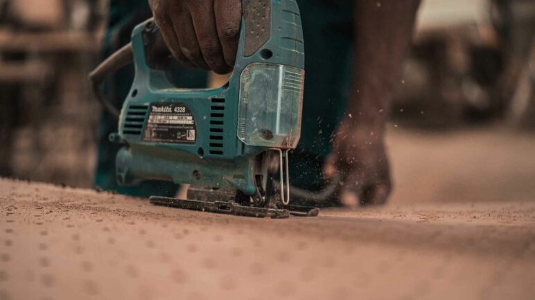 Man working on wood with a tool