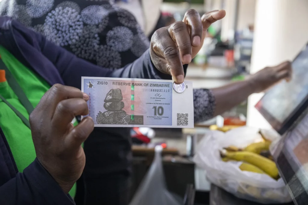 Close up of a hand holding zimbabwes new  gold backed digital currency note and coin issued by the reserve bank of zimbabwe