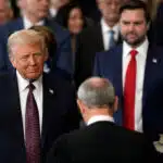 Donald trump raises his hand during the oath of office as the 47th president of the united states with chief justice john roberts presiding and melania trump holding the bible