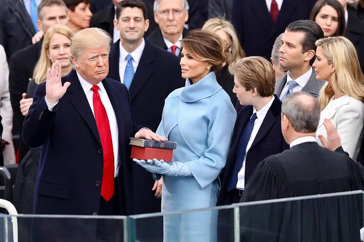 Donald Trump being sworn in as the 45th President of the United States, with Melania Trump holding the Bible and Chief Justice John Roberts presiding.