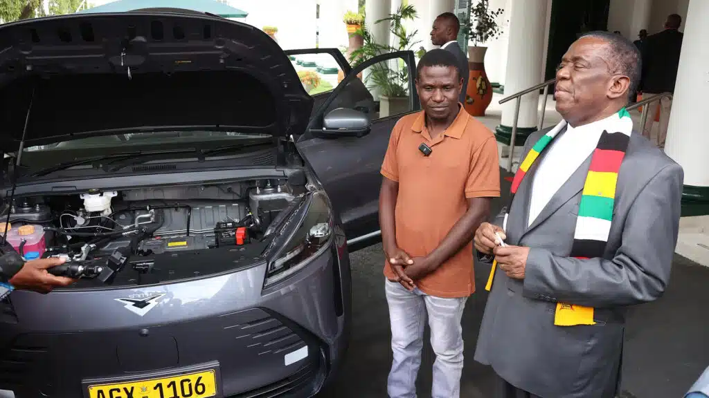 Zimbabwean president emmerson mnangagwa and inventor maxwell chikumbutso stand beside a self powering vehicle with an open hood at state house in harare discussing groundbreaking technology