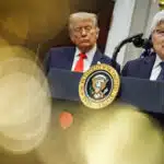 TSMC CEO C.C. Wei speaks at a podium in Washington, D.C., announcing a $100 billion U.S. investment, while President Donald Trump stands behind him.