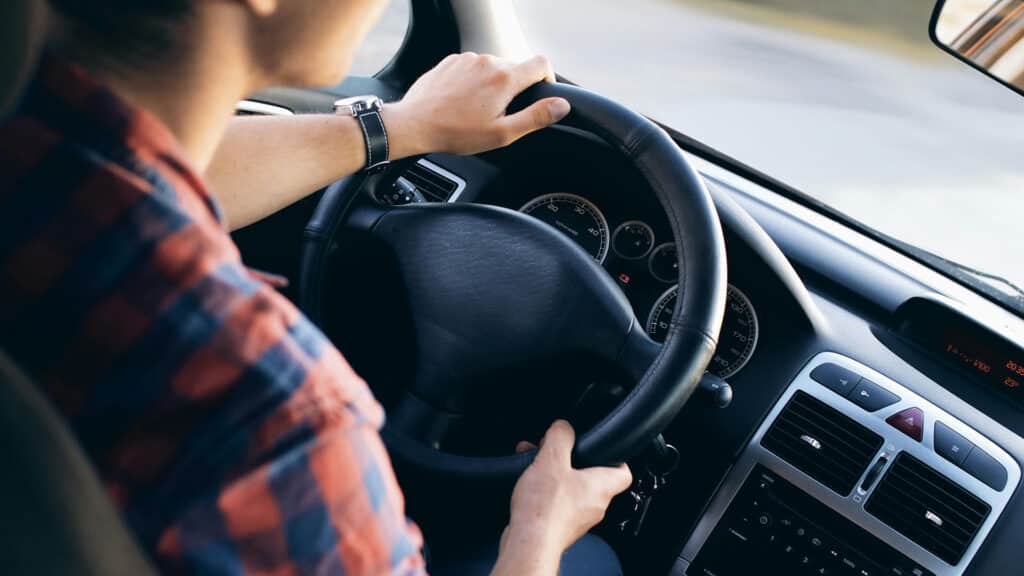 Man driving car with both hands on the wheel