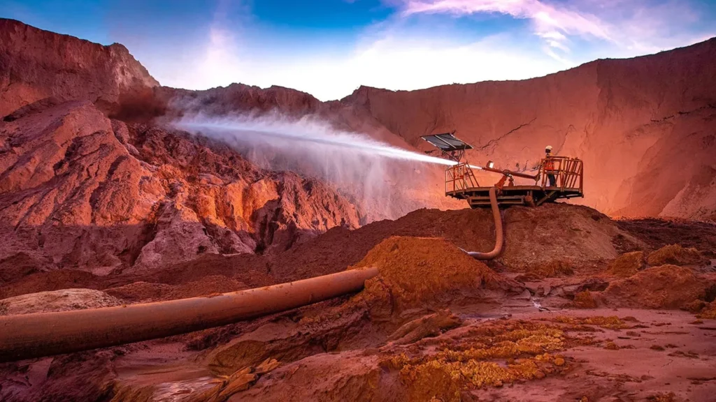 Open-Pit Mining Operations in Kenya | Brimco Water spraying system operating at an open pit mine in kenya with red earth terrain and mining equipment visible at dusk